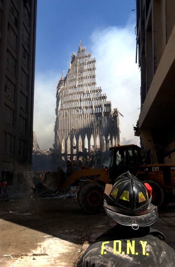 A New York City firefighter looks up at what remains of the World Trade Center after its collapse during the Sept. 11