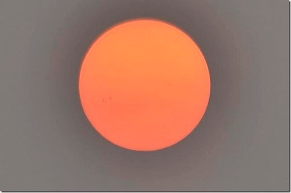 The sun over San Juan Islands is cloaked in a heavy fog of smoke as wildfires burn