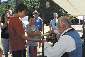 Living history re-enactor Patrick Haas pours out a bit of musket black powder for all to see during Encampment 2013