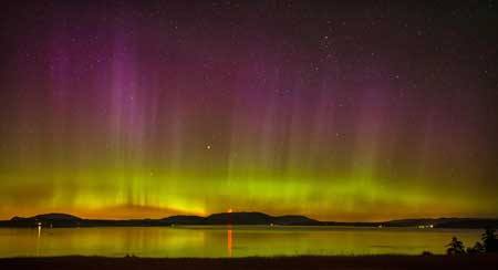 A view from Reboudt Road at the south end of San Juan Island reveals the Northern Lights aglow over Orcas Island on the evening of July 15.