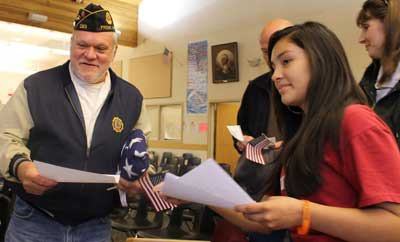 Friday Harbor middle school students bestow gifts and notes of appreciation upon Vietnam veteran Peter DeLorenzi and fellow vets as part of the Quest Class’s yearly Veterans Day observance.