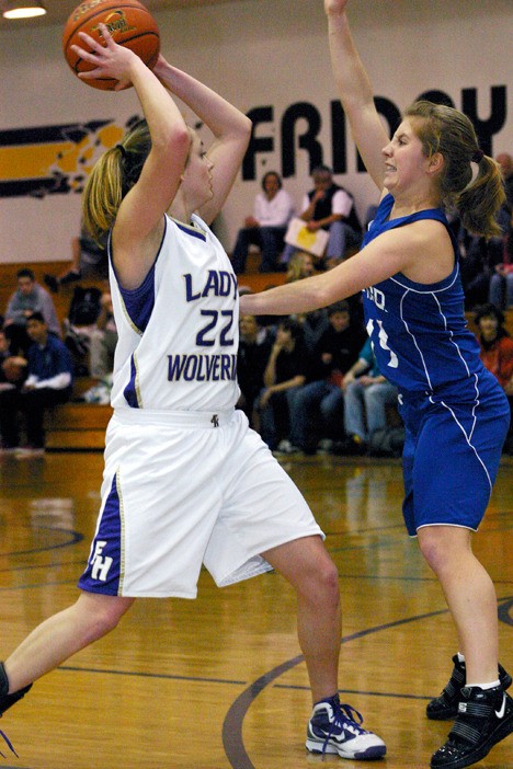 Friday Harbor senior Kayla Short (22) looks to complete a pass