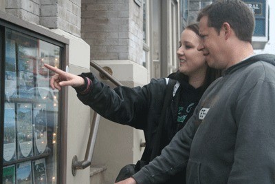 Seattle’s Carter and Sarah Green survey real estate listing on Coldwell Banker building while on a visit to Friday Harbor