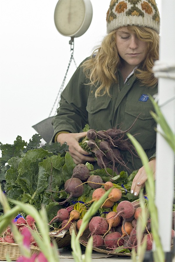 Raina Drake-Raue works at the Thousand Flower Farm stand at the Friday Harbor Farmers Market. The Farmers Market has been an incubator for several ag-related businesses.