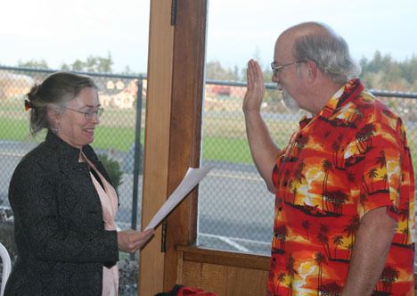 Friday Harbor Port Executive Director Marilyn O'Connor administers the oath of office to Commissioner Greg Hertel