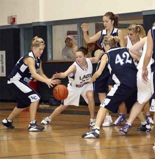 Junior Kayla Short battles Lynden Christian’s Heidi Robins and other Lyncs for a loose ball during the Wolverines’ 68-25 defeat at home Saturday.