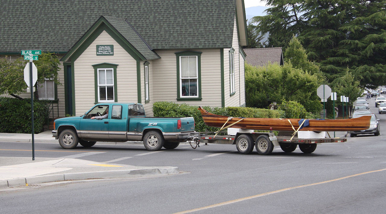 Staff photo/Hayley Day                                Malcolm Suttles drives a 125-foot canoe through town on Monday, July 10.